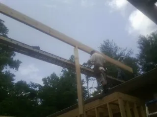 Carpenter setting a ridge beam over a new addition frame — Ice Dam Removal by Roofing Brothers in Northvale