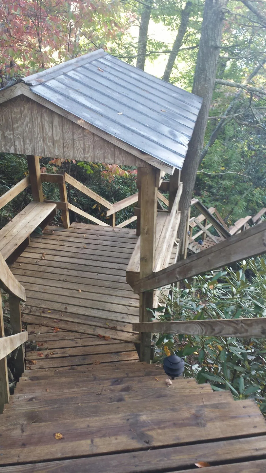 Metal roofed shelter over wooden steps on a wooded walkway — Skylight Repair & Installation work by our crew in Northvale