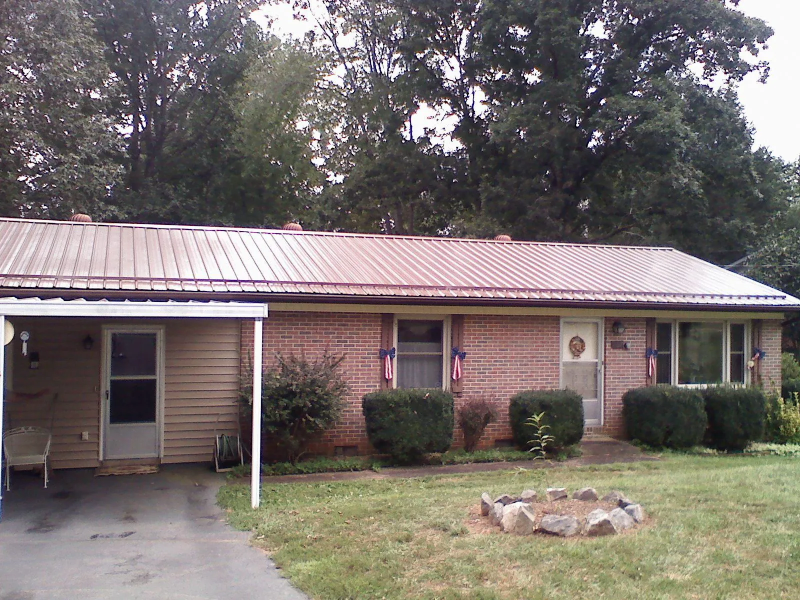 Bronze metal roof and carport on a brick ranch home — Roof Repair work by our crew in Northvale